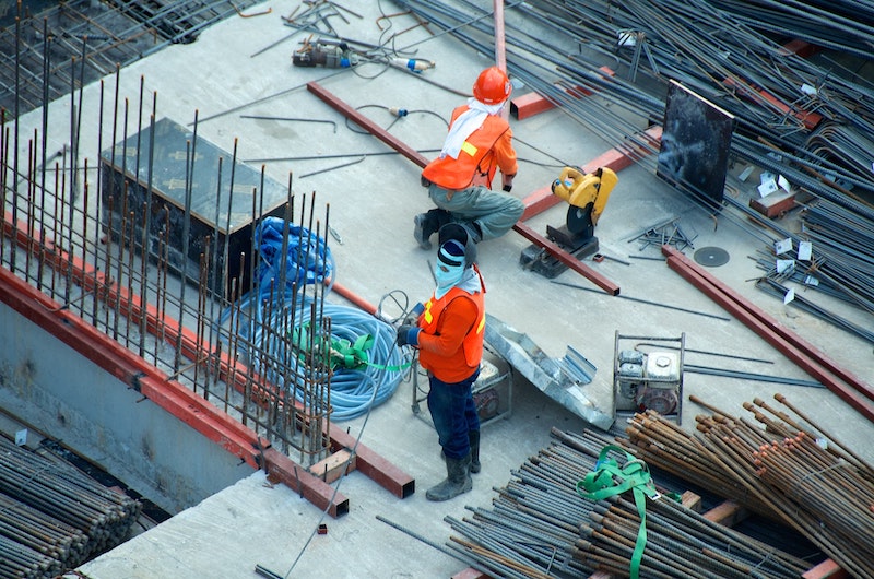 Construction workers at a site with a lot of steel beams